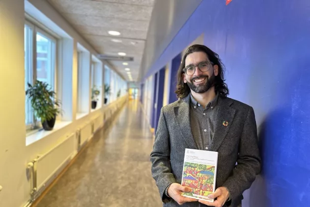 Juan Ocampo with his thesis in a corridor. Photo